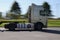 A motion blurred truck pulls a trailer at high speed