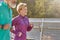 In motion. Cheerful active mature woman in sportswear smiling while running on a sunny day. Joyful senior couple doing