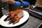 Motion of chef cutting roasted duck into a plate