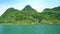 Motion past forestry hills on river bank under blue sky