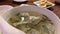 Motion of people eating dumpling soup and appetizers on table inside Chinese restaurant