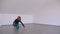 Motion shoot of young beautiful skilled female performing an emotional dance in the empty room indoors in a flat