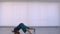 Motion shoot of young cute flexible female performing an emotional dance in the empty room indoors in the apartment