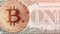 Motion shot of coin of bitcoin on banknote of one dollar banknote