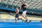 motion shot of young male and female joggers running on track