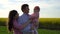 Motion video happy family: father, mother and daughter having fun outdoors in field in summer