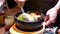 Motion of waiter stirring Korean bibimbap for customer on table