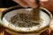 Motion of woman mashing sesame out inside bowl