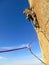 motivate traditional rock climber working his way up a cliff