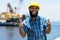 Motivated african american offshore worker with digger and ocean