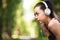 Motivated asian jogger girl with headphones resting during training at park