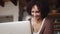 Motivated biracial mother working on laptop at home in her modern-styled kitchen.