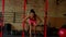 Motivated fitness black female doing cross training with battle ropes in gym