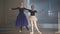 Motivated girl and confident woman doing tendu movement in ballet studio indoors. Wide shot portrait of Caucasian