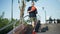 Motivated handsome mature amputee with prosthesis standing on sunny day outdoors with basketball ball looking away. Wide