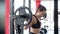 Motivated sportswoman squatting with heavy barbell on shoulders, active workout