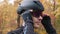 Motivated young cyclist athlete in black helmet puts on sport glasses before workout on bike. Extra close up view. Cycling trainin