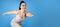 Motivated young sportswoman running over blue background, web-banner