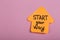 Motivation concept - orange sticky note in shape of arrow with text Start your way