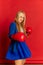 Motivation for success. Funny young business woman or happy student wearing blue suit boxing over bright red background