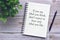 Motivational and inspirational quote on notebook with pen and plant