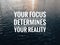 Motivational and inspirational quote with phrase YOUR FOCUS DETERMINES YOUR REALITY