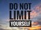 Motivational quote of do not limit yourself with a blurry background of sunset clouds view