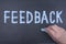 Motivational Text sign showing Give us Feedback on a chalkboard