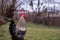 A motley rooster sitting with hens in the garden nibbling green grass. chickens at the farm in the nature at the village