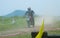 Motocross biker rider behind dust cloud.