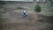 Motocross racer jumping. Rear view of biker on track in slow motion