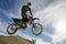 Motocross Racer In Midair Against Cloudy Sky