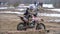 Motocross. Racer starts his motorcycle on the track. Off-road racing on enduro bikes. Slow motion