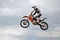 Motocross rider jumps high against the sky