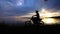 Motocross rider starting engine in his enduro bike. Sunset, sky and river