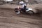 Motocross rider veering point-blank of sand with