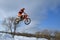 Motocross winter, high flying motorcycle racer over snowdrifts