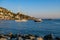 A motor boat and a sailing ship enter the bay of Roses