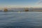 A motor boat sails in Bocca d`Arno near the wooden huts famous for trebuchet fishing, Marina di Pisa, Italy