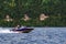 Motor boat sails over the reservoir on a sunny day. Small ship with tourists on board touring on reservoir