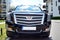 Motor car Cadillac Escalade at the city street. Cadillac Escalade SUV commands attention with its superior craftsmanship and iconi