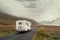 Motor home on a small asphalt road into mountains,