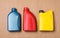 Motor oil in different canisters on light brown background, flat lay