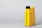 Motor oil in yellow canister on grey marble table against light background, space for text