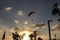 Motor paraplan flies in the sky between the clouds in the setting sun