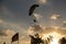 Motor paraplan flies in the sky between the clouds in the setting sun