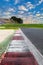 Motor sport circuit asphalt track background curb close up on straight and green field