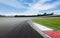 Motor sport circuit asphalt track background curb close up on straight and green field