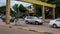 Motor traffic on a city street in southeastern Asia, cloudy weather, yellow arch with inscriptions