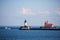 Motor yacht passing by the lighthouse on North Pier in Duluth Harbor